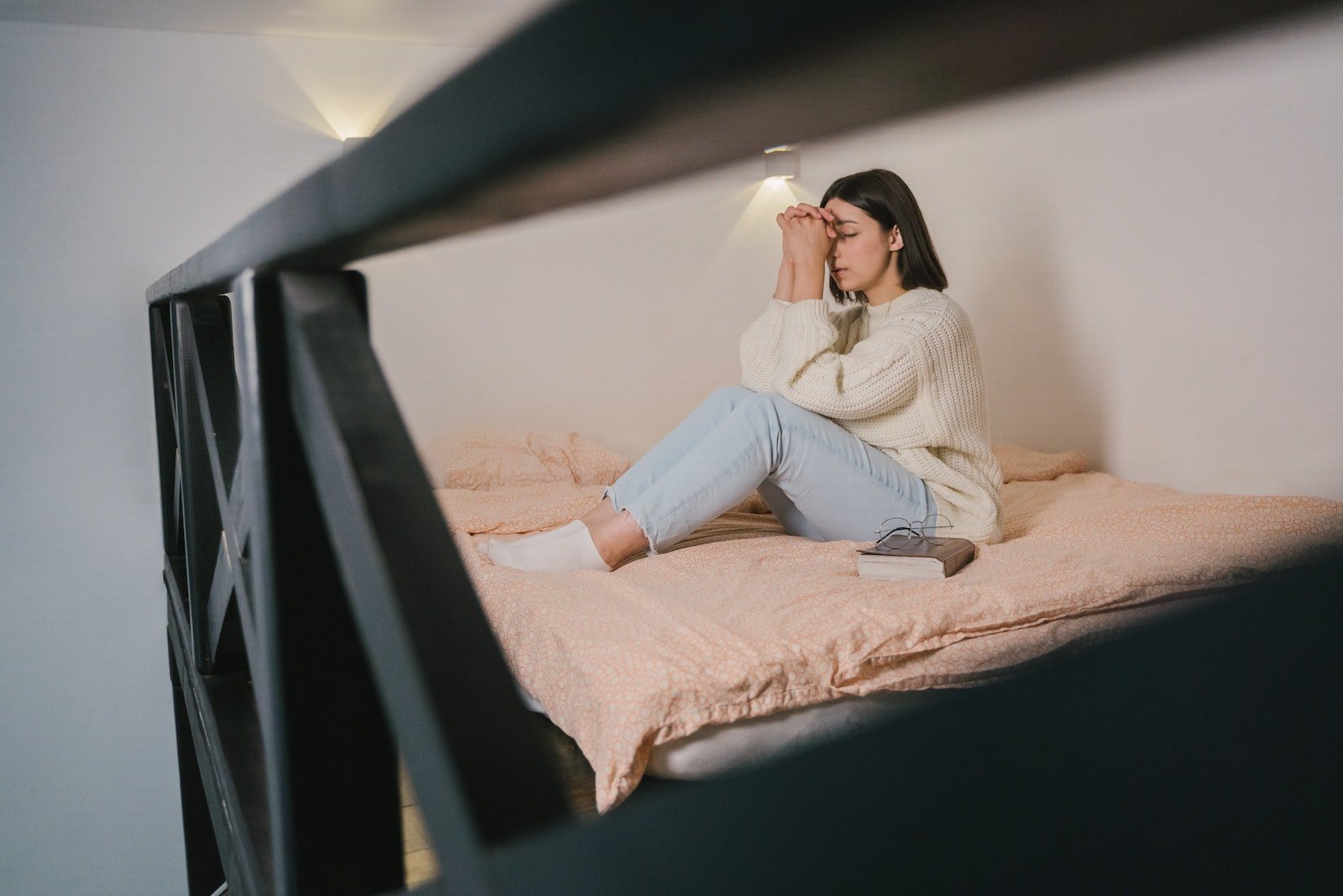 Oración para encontrar trabajo, Woman in White Sweater and Blue Denim Jeans Sitting on Bed