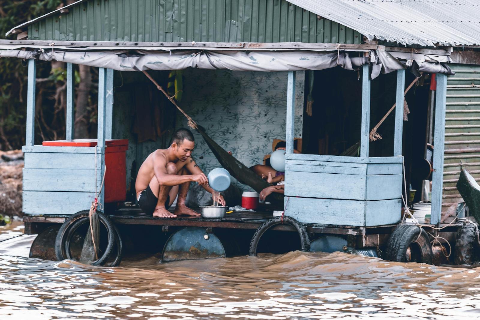 Oración por la Vivienda, Man Pouring Water from Dipper on Blue and Grey House