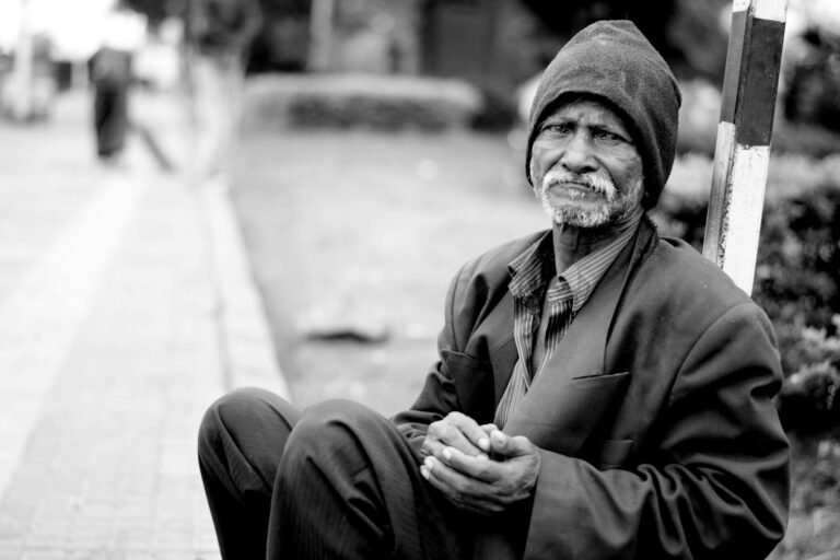 Oración por los Desamparados, Grayscale Photography of Man Sitting