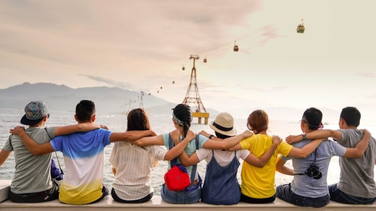 cómo ganar amigos, people holding shoulders sitting on wall