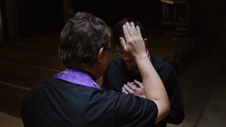 confesión sacramental, priest touching man's forehead