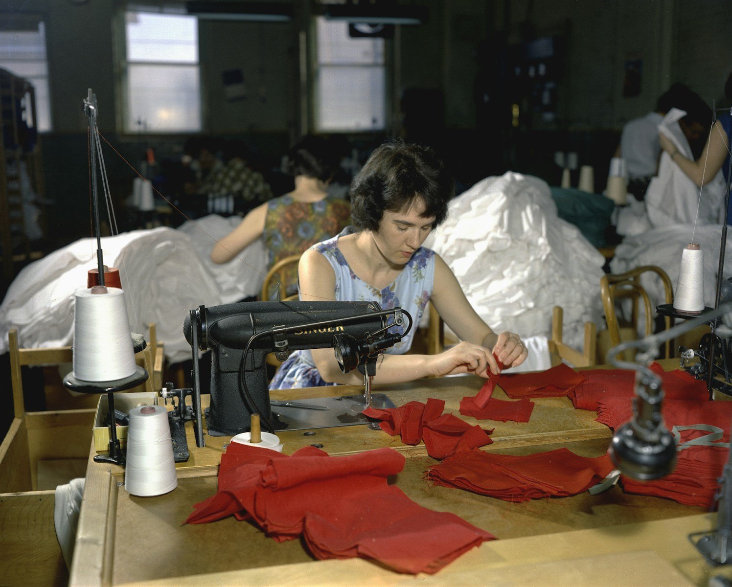 sentido del trabajo, a woman sitting at a table with a sewing machine