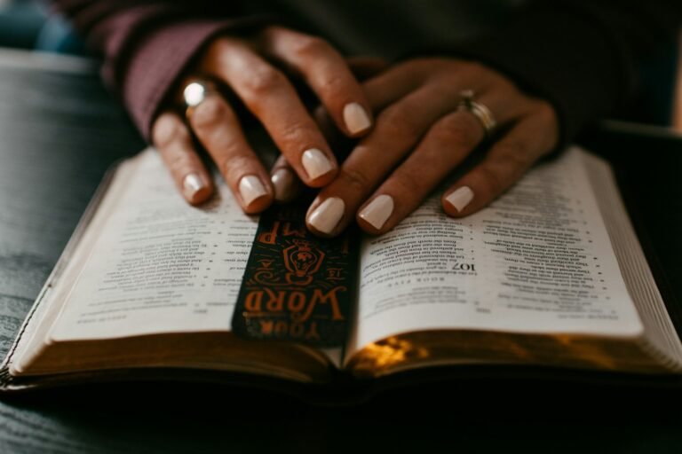cansancio espiritual, person wearing silver ring on ring finger on book page