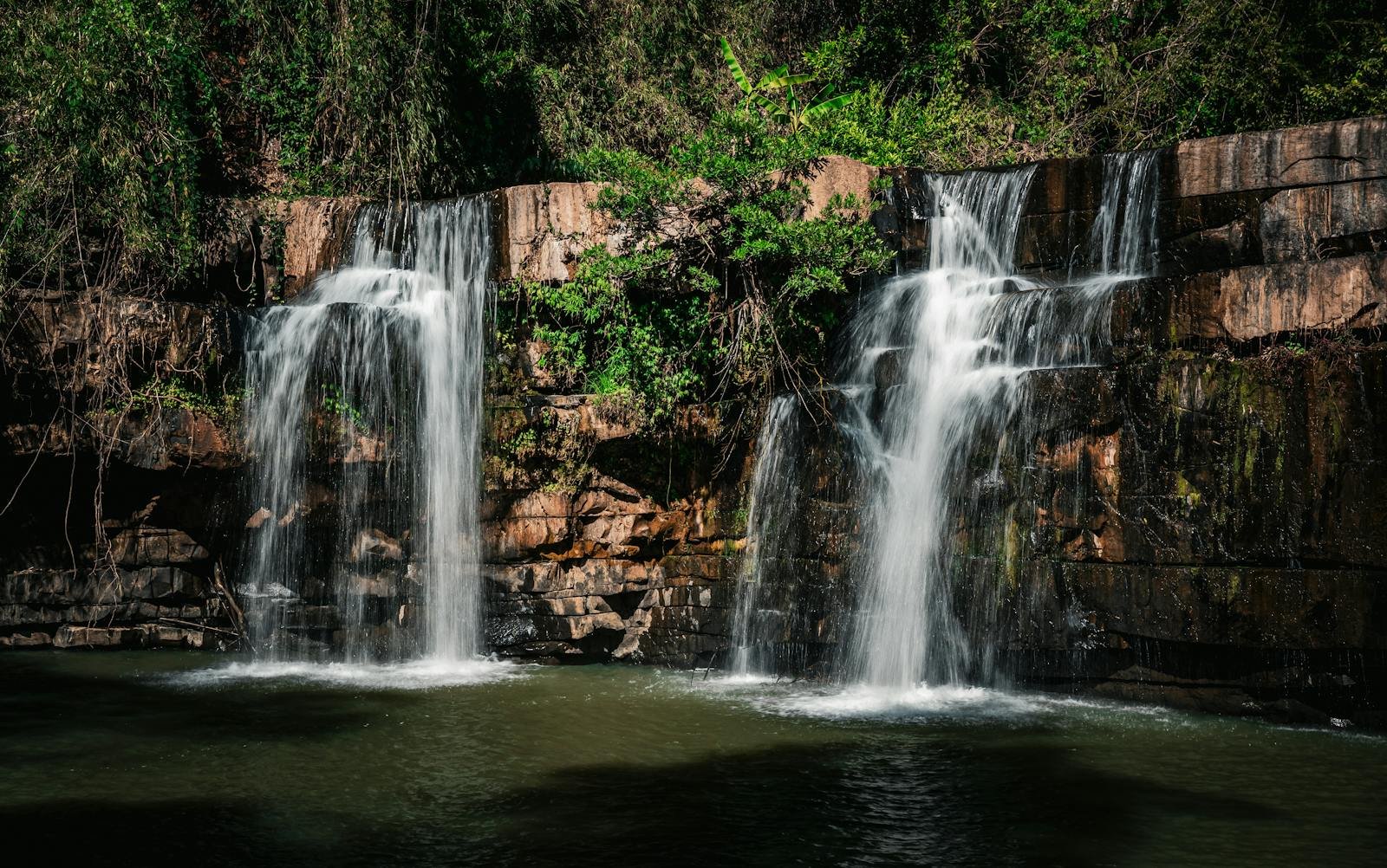 gratitud diaria, A serene waterfall cascading over rocks in the lush forest of Thailand.