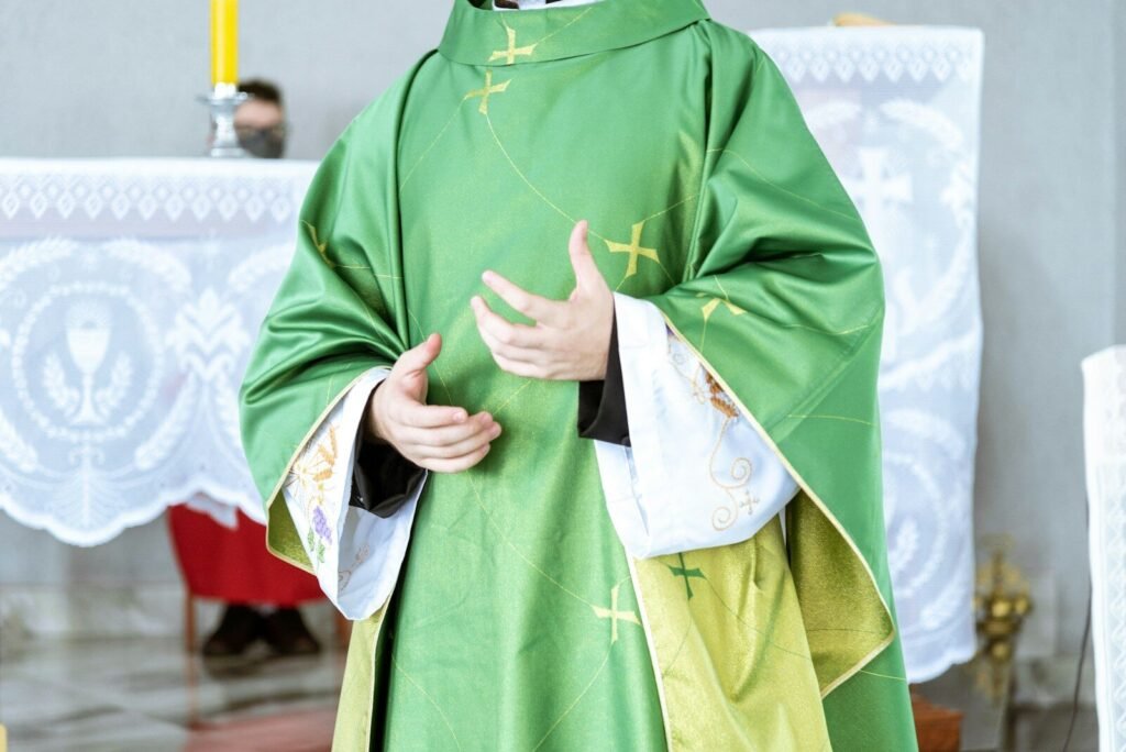 por qué el sacerdote se viste así, a man in a priest's outfit standing in front of a cross